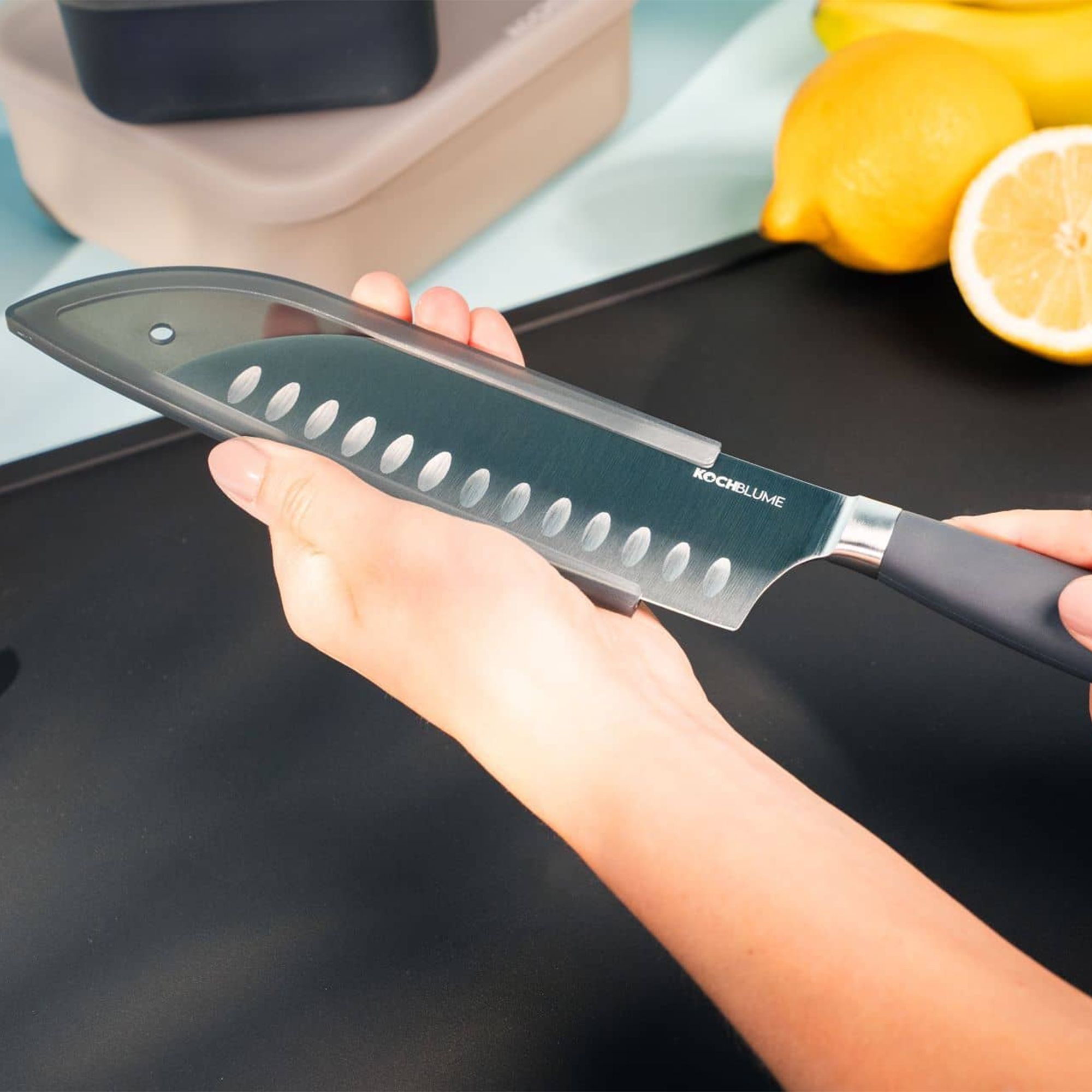 Person holding chef’s knife with blade cover